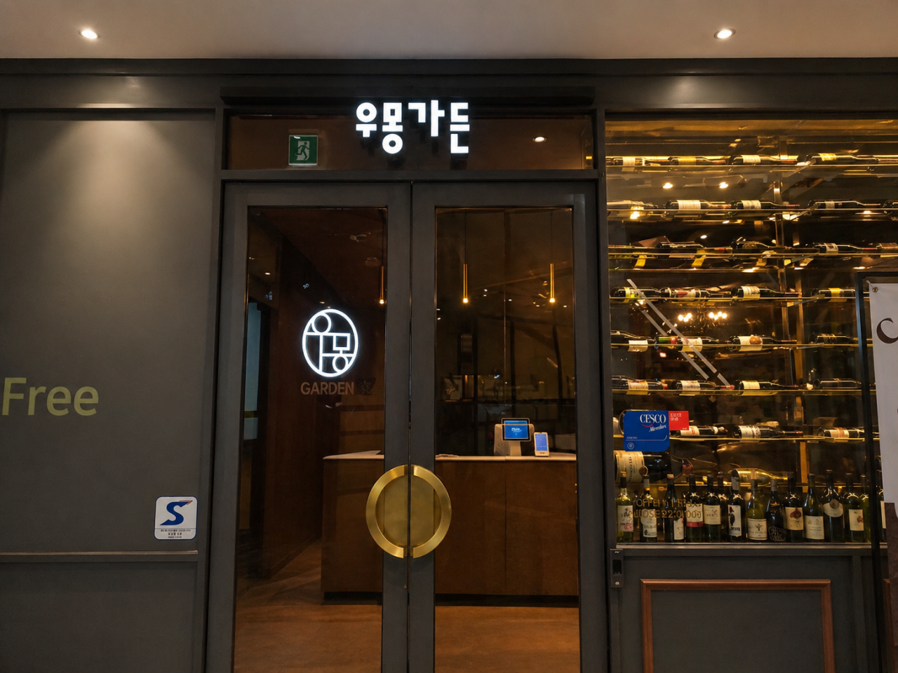 Entrance vestibule with circular brass door pull and floor-to-ceiling wine wall